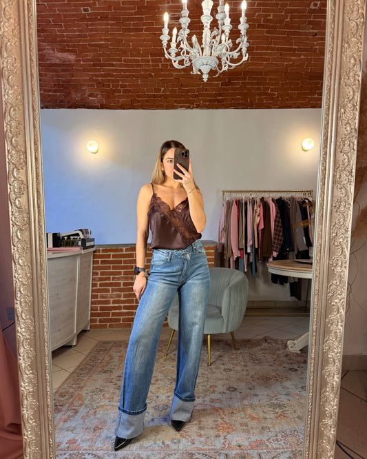 Jeans con chiusura asimmetrica e maxi risvolto